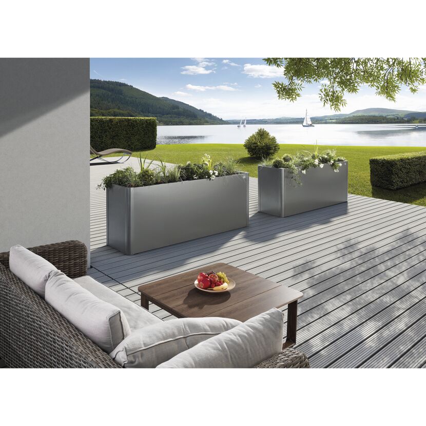 Zwei graue Pflanzkübel auf einer Terrasse am See