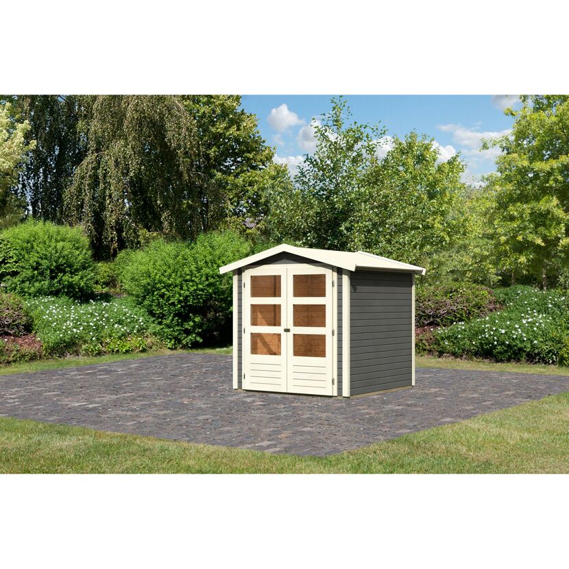 Grau-beiges Gartenhaus auf gepflastertem Untergrund
