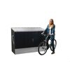 Person lehnt an Fahrradbox mit Fahrrad