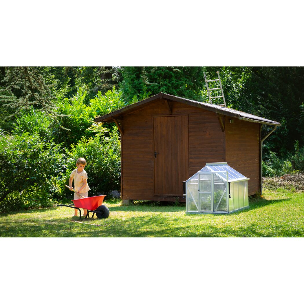 Kind mit Schubkarre und Schaufel im Garten