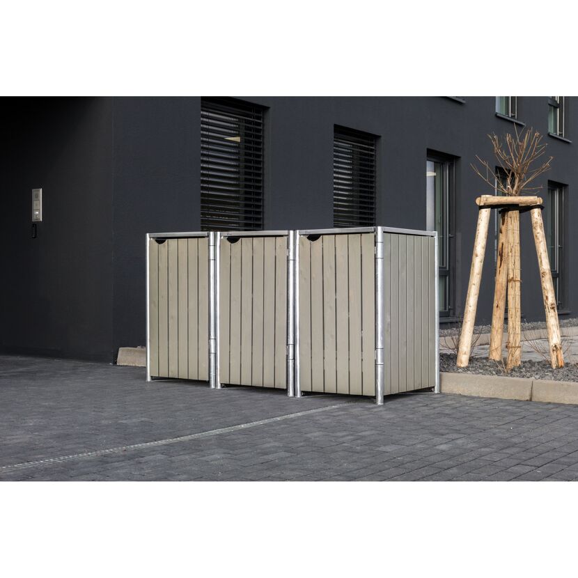 Zwei Mülltonnenboxen vor einem Gebäude.