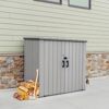 Grauer Geräteschrank mit Axt und Holzscheiten