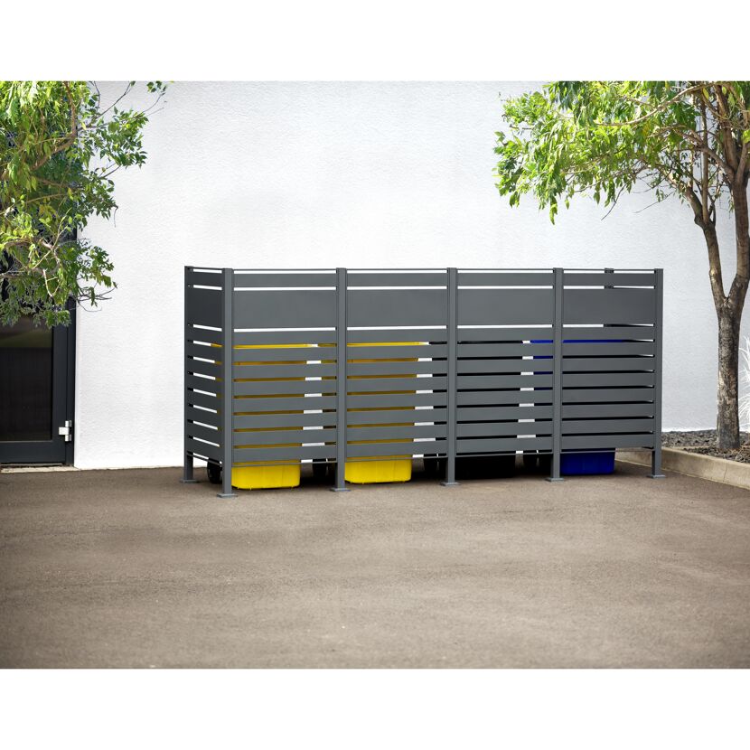 Graue Mülltonnenverkleidung mit gelben und blauen Mülltonnen