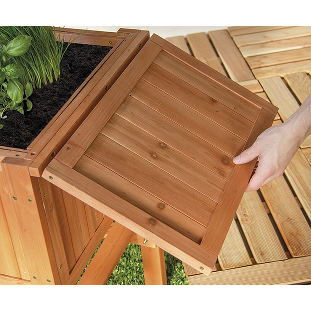 Person öffnet Deckel eines Hochbeets aus Holz