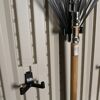 Rechen an Garagenwand