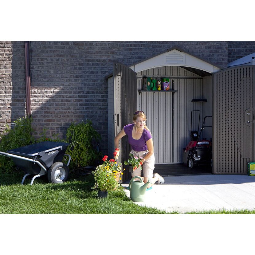 Person beim Einräumen eines Gartenhauses