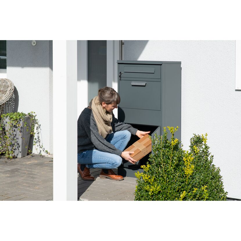 Person nimmt Paket aus Paketbox