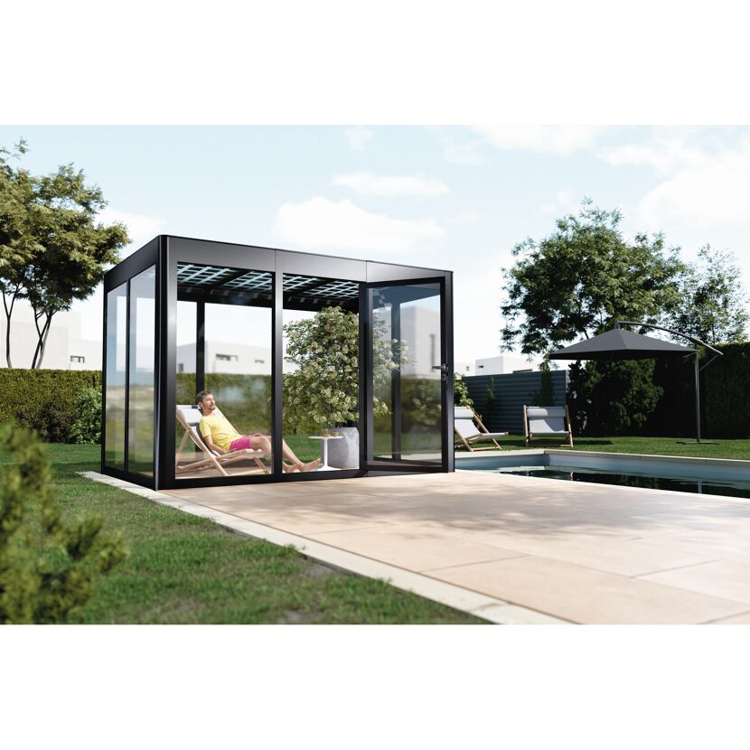 Person entspannt in einem gläsernen Gartenpavillon am Pool