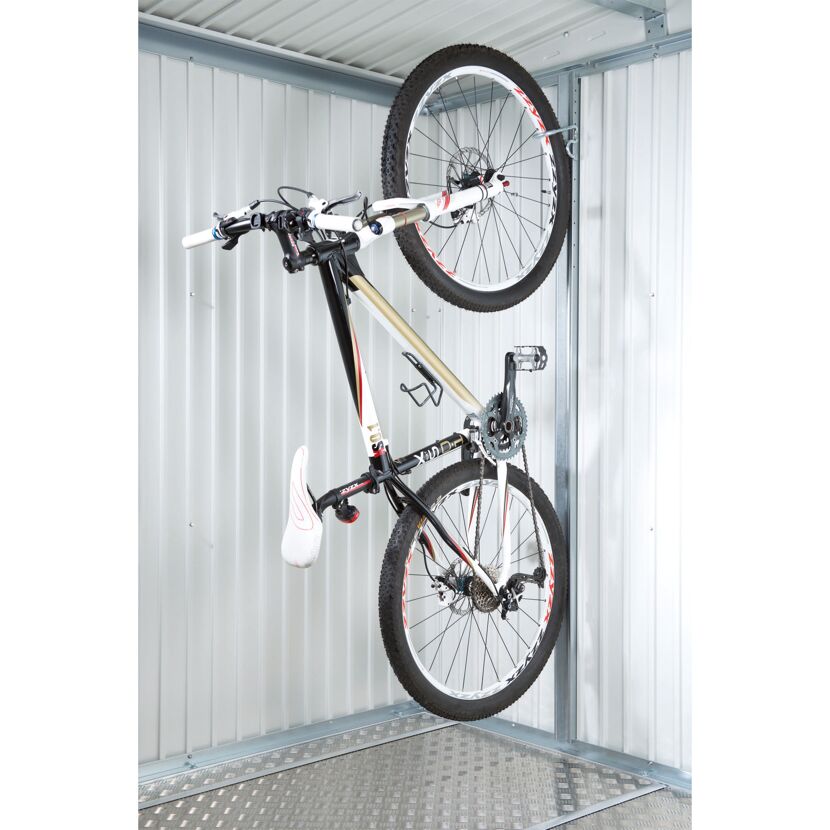 Fahrrad hängt an Fahrradhalterung in einem Gerätehaus.
