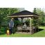 Zwei Personen entspannen sich in einem Gartenpavillon. Eine Person grillt.