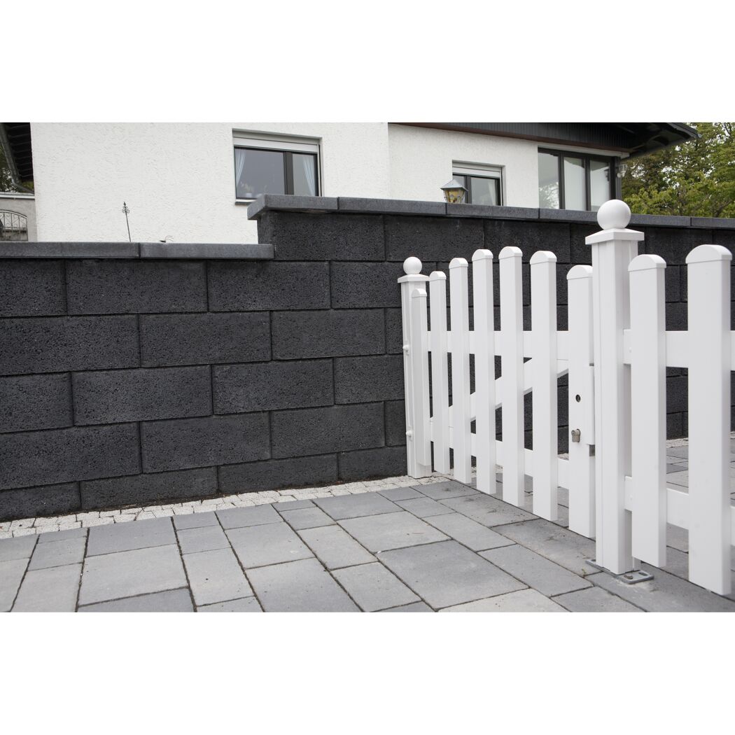 Schwarze Mauer und weißer Gartenzaun