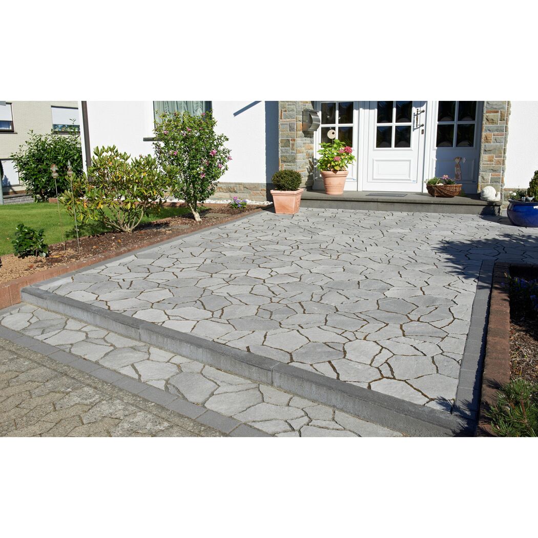 Pflasterfläche mit grauen Pflastersteinen und Stufen