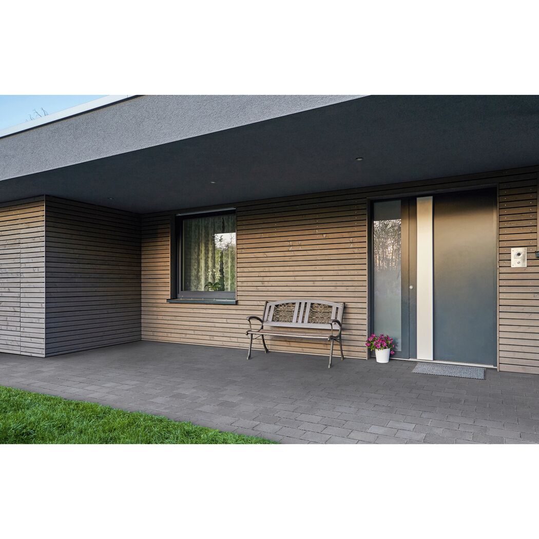 Hausfassade mit Bank und grauen Bodenfliesen