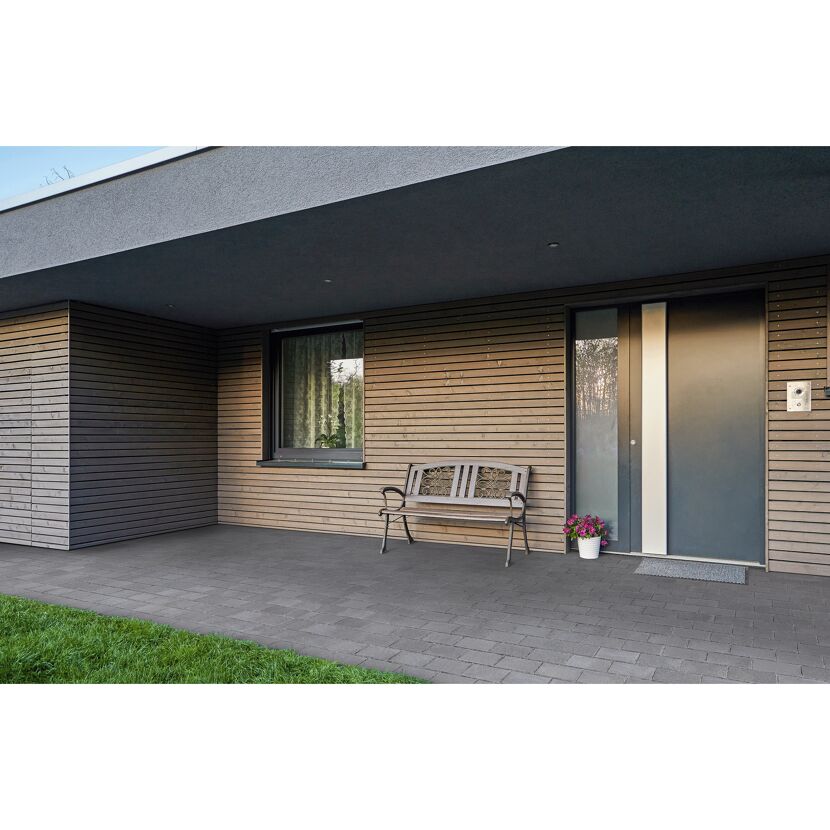 Hausfassade mit Bank und grauen Bodenfliesen