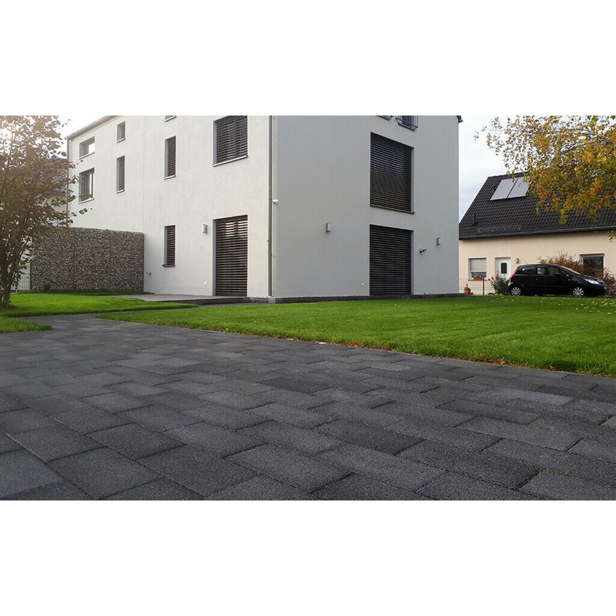 Anthrazitfarbener Plattenweg und Rasenfläche neben einem Haus