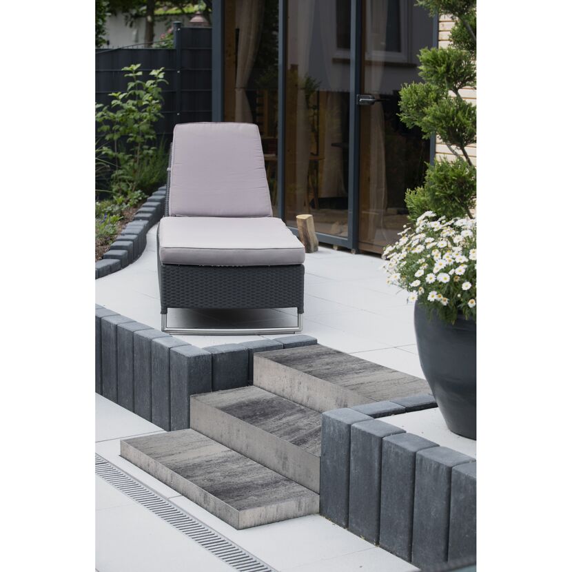 Gartenliege auf Terrasse mit Blockstufen und Pflanzen