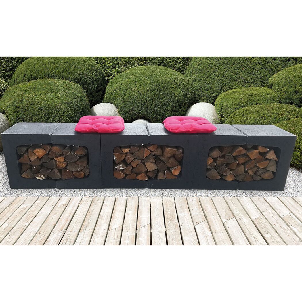 Schwarze Gartenbank aus Beton mit rotem Sitzkissen und Brennholz