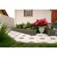 Gepflasterter Gartenweg mit Blumen und Beet