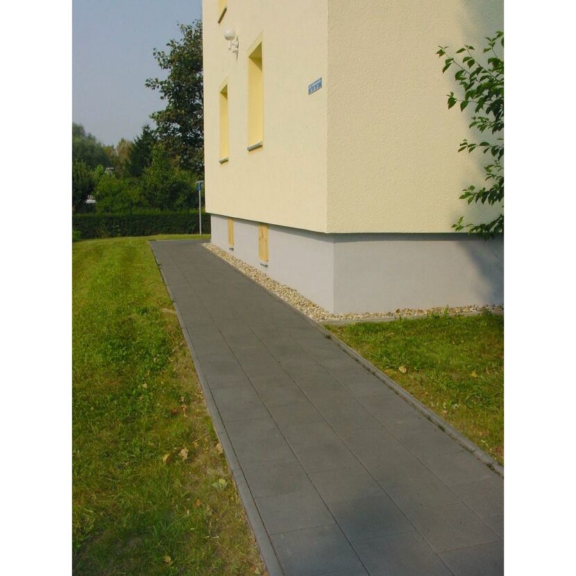 Anthrazitfarbener Gehweg neben einem Haus