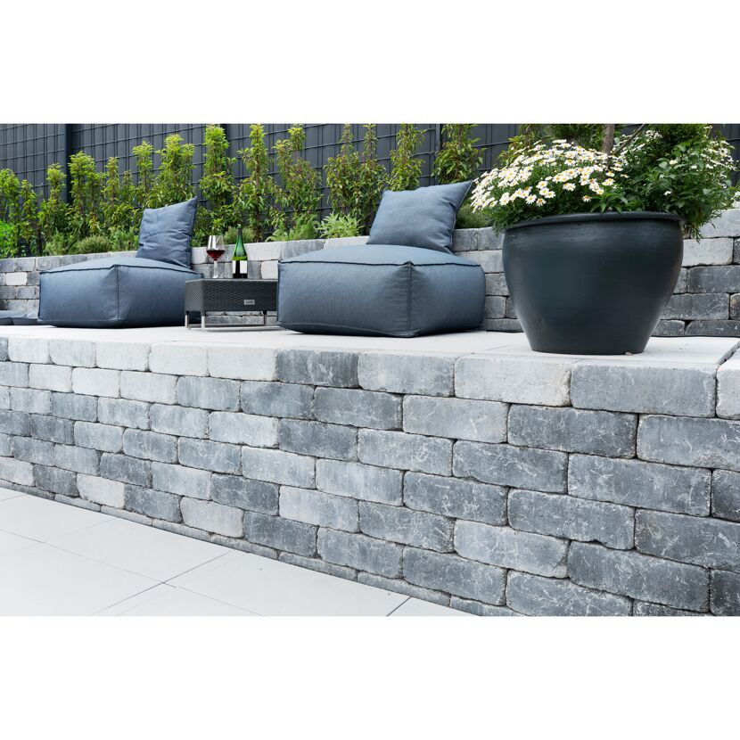 Sitzecke auf einer Steinmauer im Garten