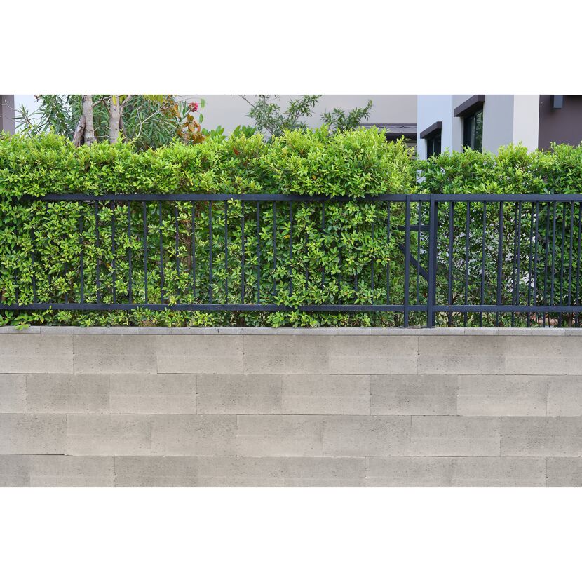 Gartenmauer mit schwarzem Metallzaun