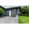 Grauer Gehweg vor einem Haus mit Garten