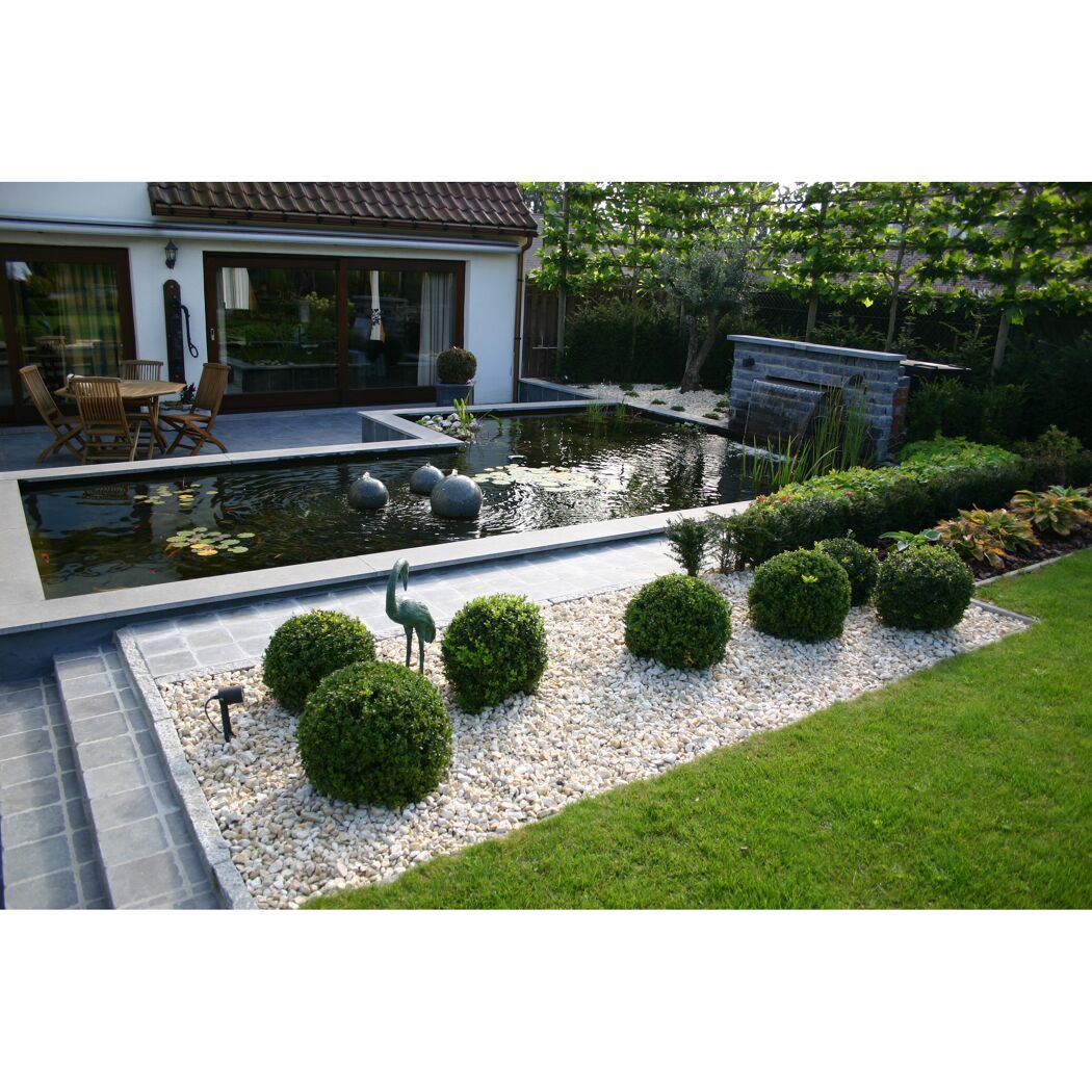 Moderner Gartenteich mit Wasserfall und Dekorationen.
