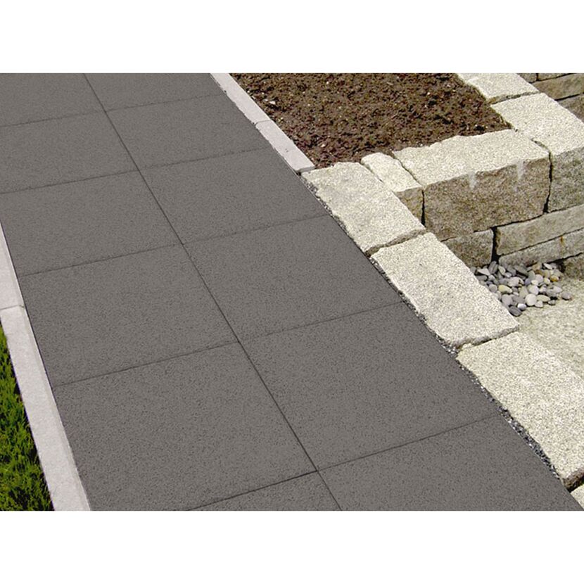 Graue Gehwegplatten neben einem Beet mit Granitsteinen
