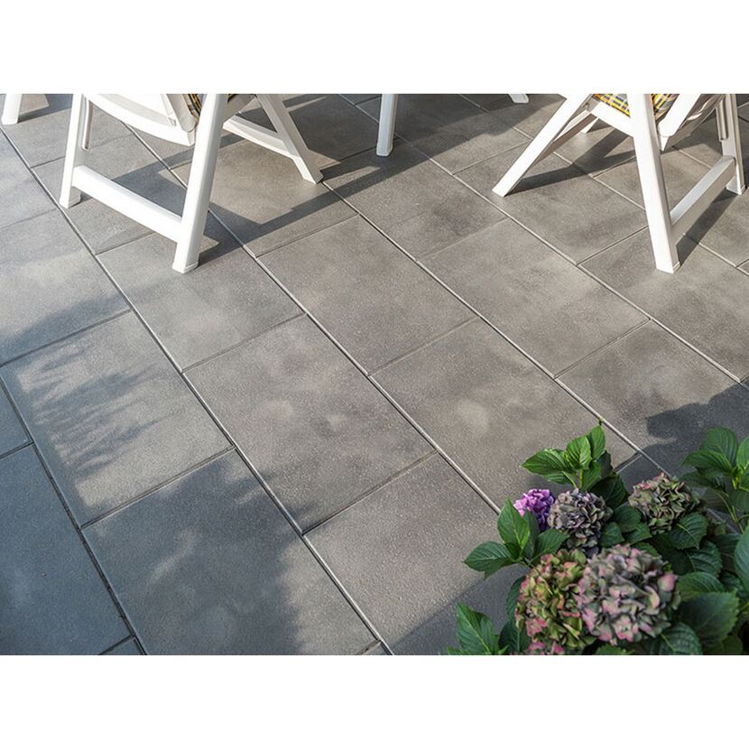 Graue Terrassenplatten mit Gartenstühlen und Pflanzen