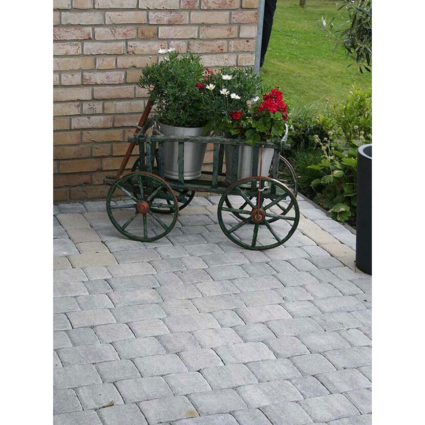 Bollerwagen mit Blumenkübeln auf gepflasterter Fläche