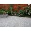 Gepflasterte Terrasse mit Blumen und Holzzaun