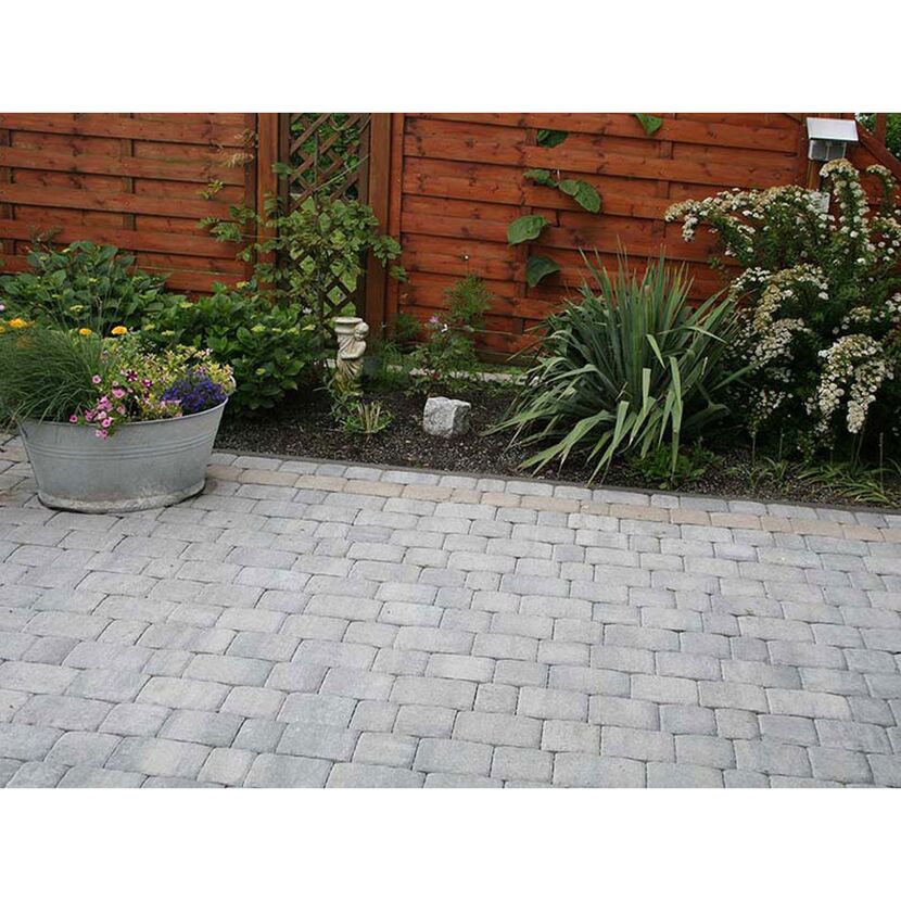 Gepflasterte Terrasse mit Blumen und Holzzaun