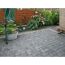 Gepflasterte Terrasse mit Blumen und Holzzaun