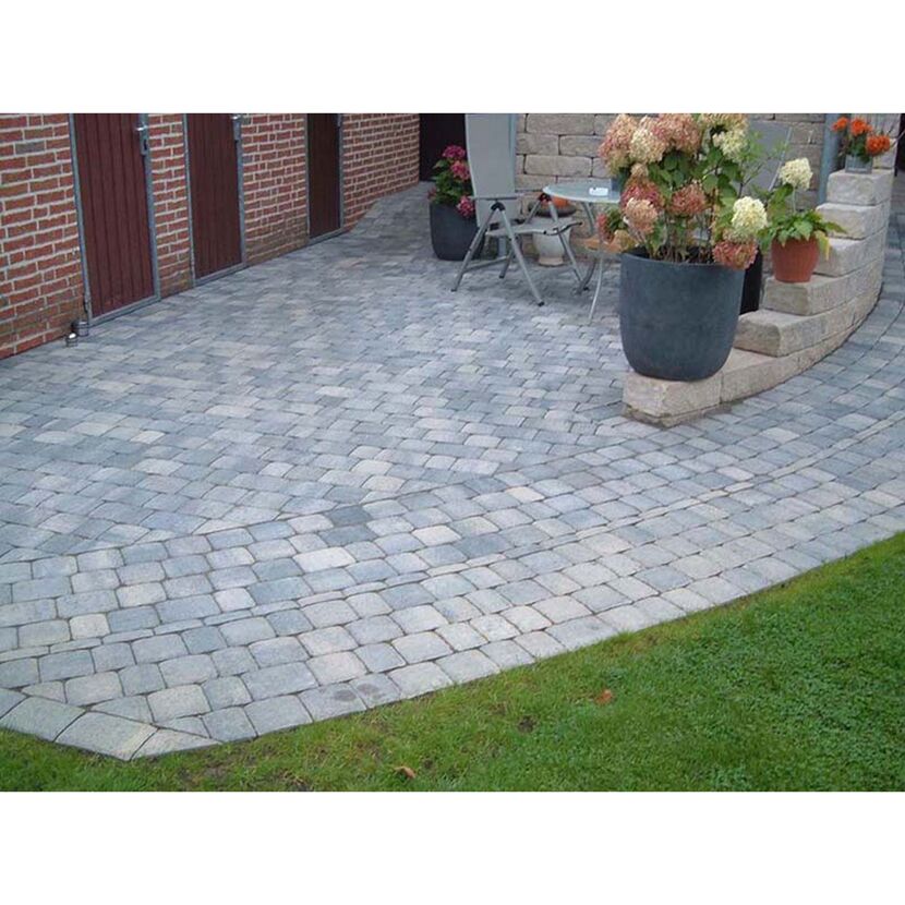 Gepflasterte Terrasse mit Gartenmöbeln und Blumentöpfen