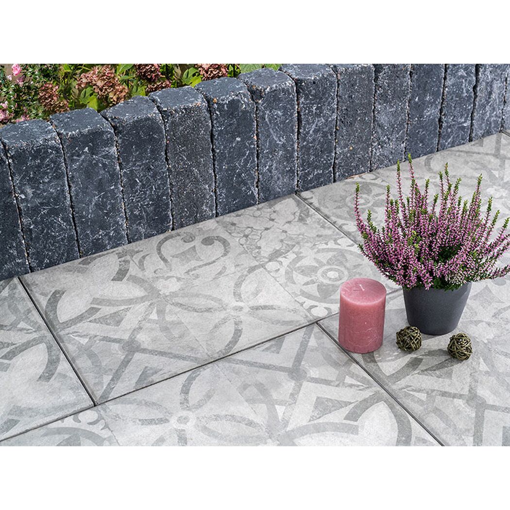 Graue gemusterte Terrassenplatten mit Deko und Pflanze