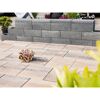 Graue Gartenmauer und beigefarbener Terrassenboden