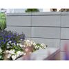 Graue Gartenmauer mit Blumenbeet