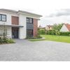 Gepflasterte Auffahrt und Vorgarten eines modernen Hauses.