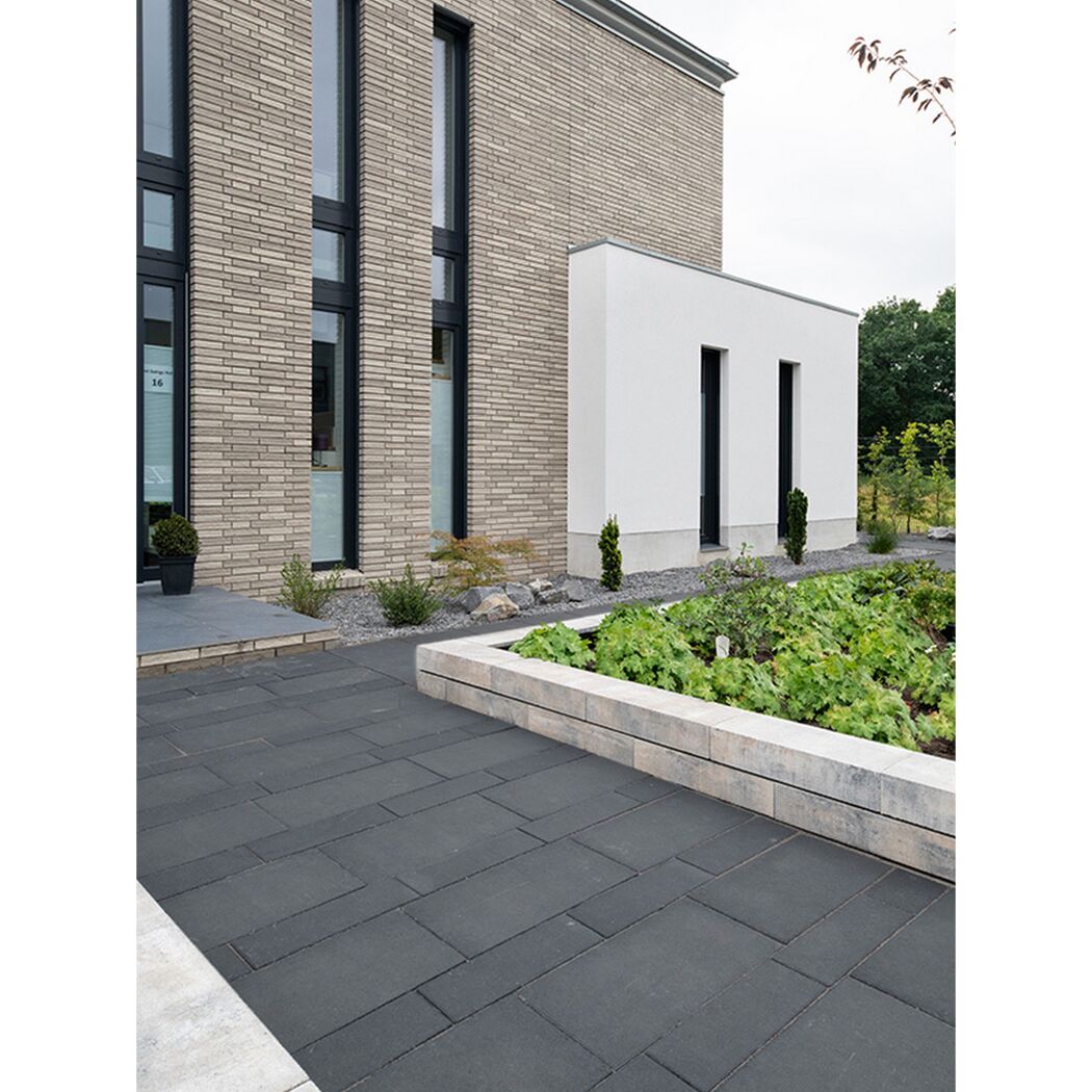 Gehwegplatten aus Basalt vor einem modernen Gebäude