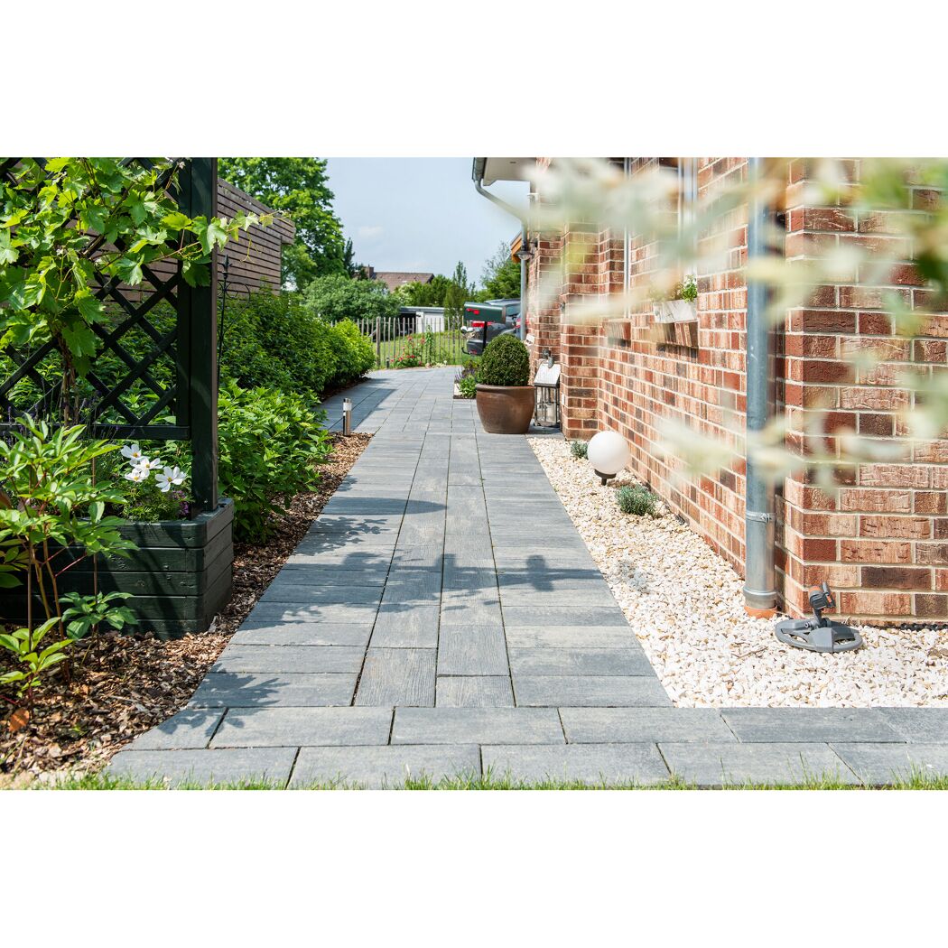 Gepflasterter Gartenweg neben einem Haus