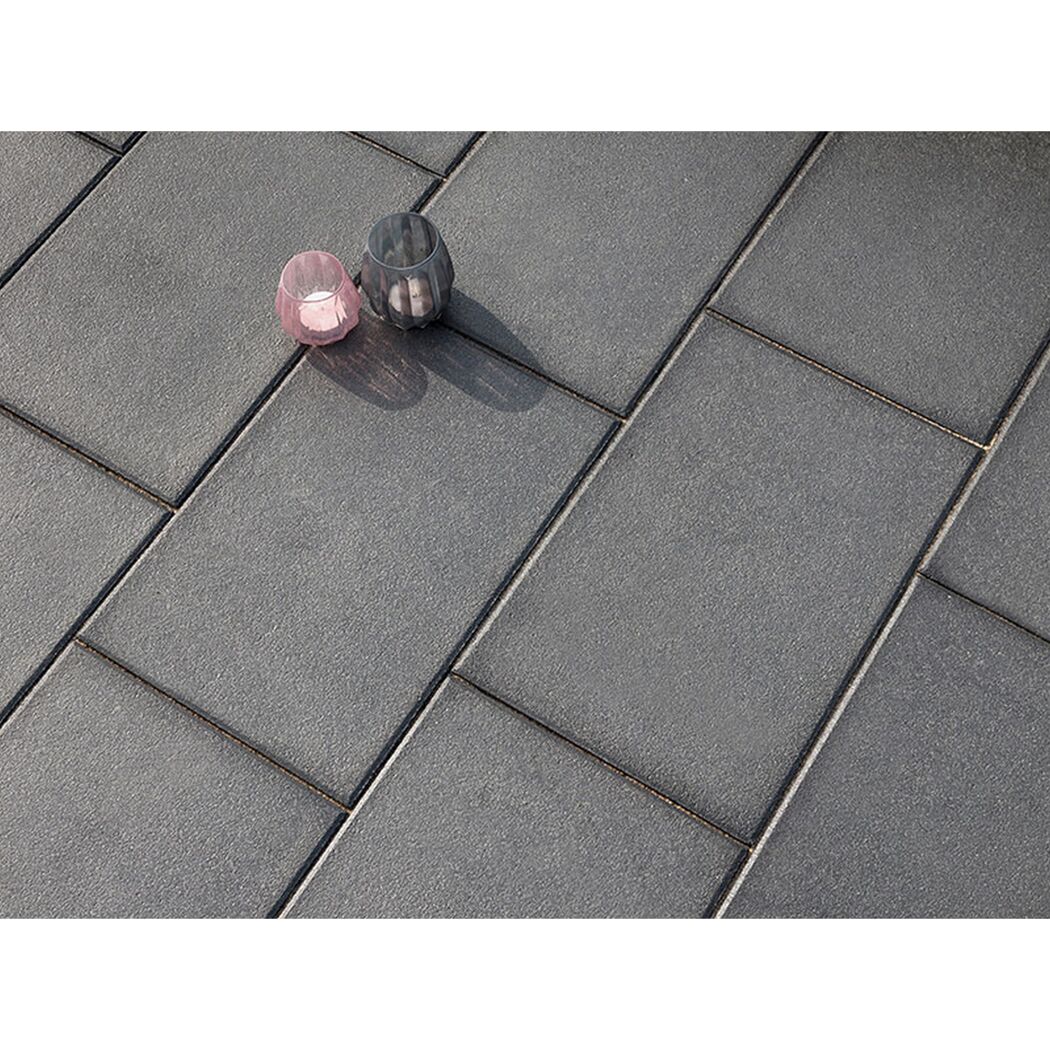 Graue Terrassenplatten mit zwei Windlichtern