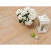 Beige Terrassenplatten mit Topfpflanze, Windlicht und Apfel