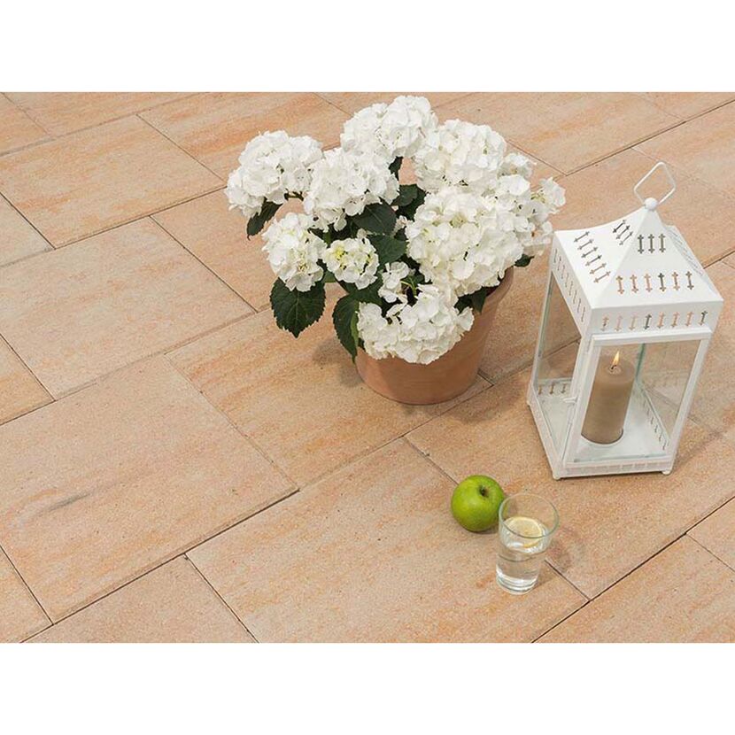 Beige Terrassenplatten mit Topfpflanze, Windlicht und Apfel