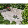 Gepflasterte Terrasse mit Blumentöpfen und niedriger Mauer