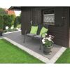 Gartenbank auf gepflasterter Terrasse vor Gartenhaus