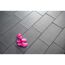 Pinke Kinderschuhe auf grauen Terrassenplatten