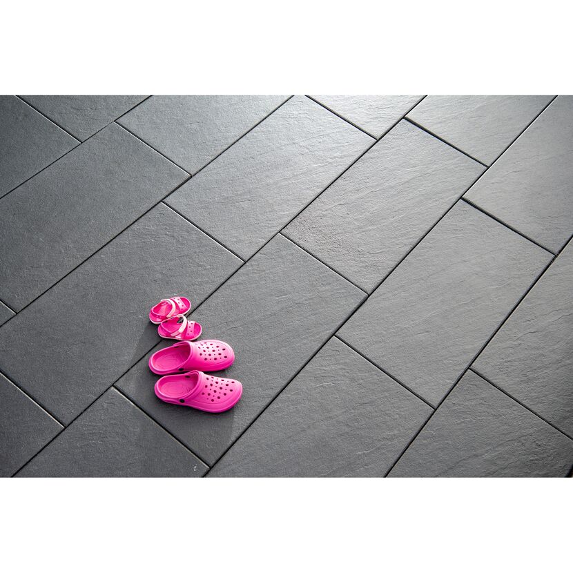 Pinke Kinderschuhe auf grauen Terrassenplatten