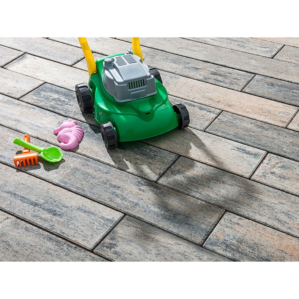 Spielzeugrasenmäher auf Terrassenplatten