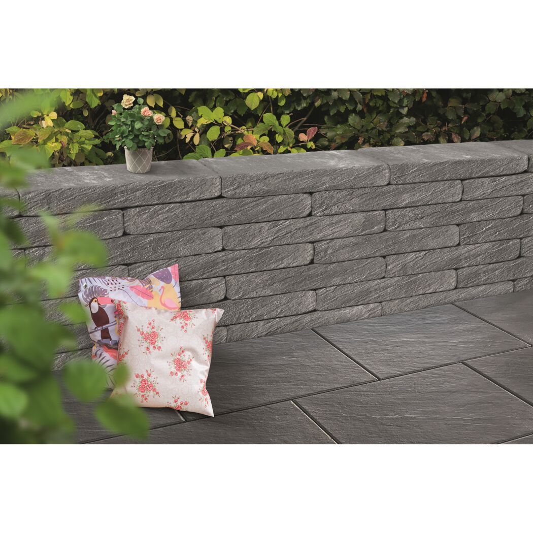 Graue Gartenmauer mit zwei Kissen davor