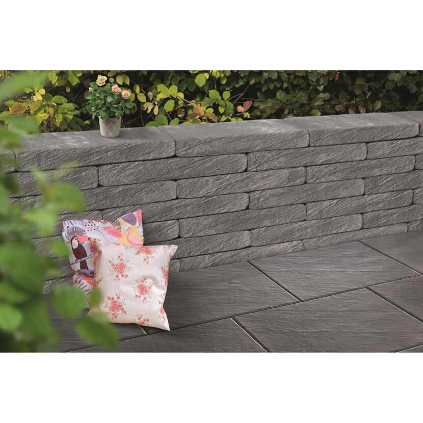 Graue Gartenmauer mit zwei Kissen davor